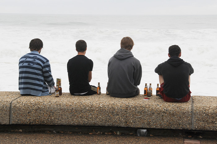 vier Menschen mit Bierflaschen